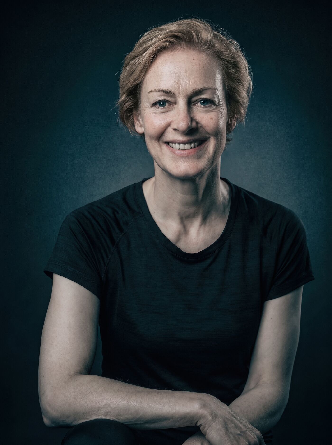Porträt von Sabine Teufert, lächelnd, die Hände locker gefaltet
